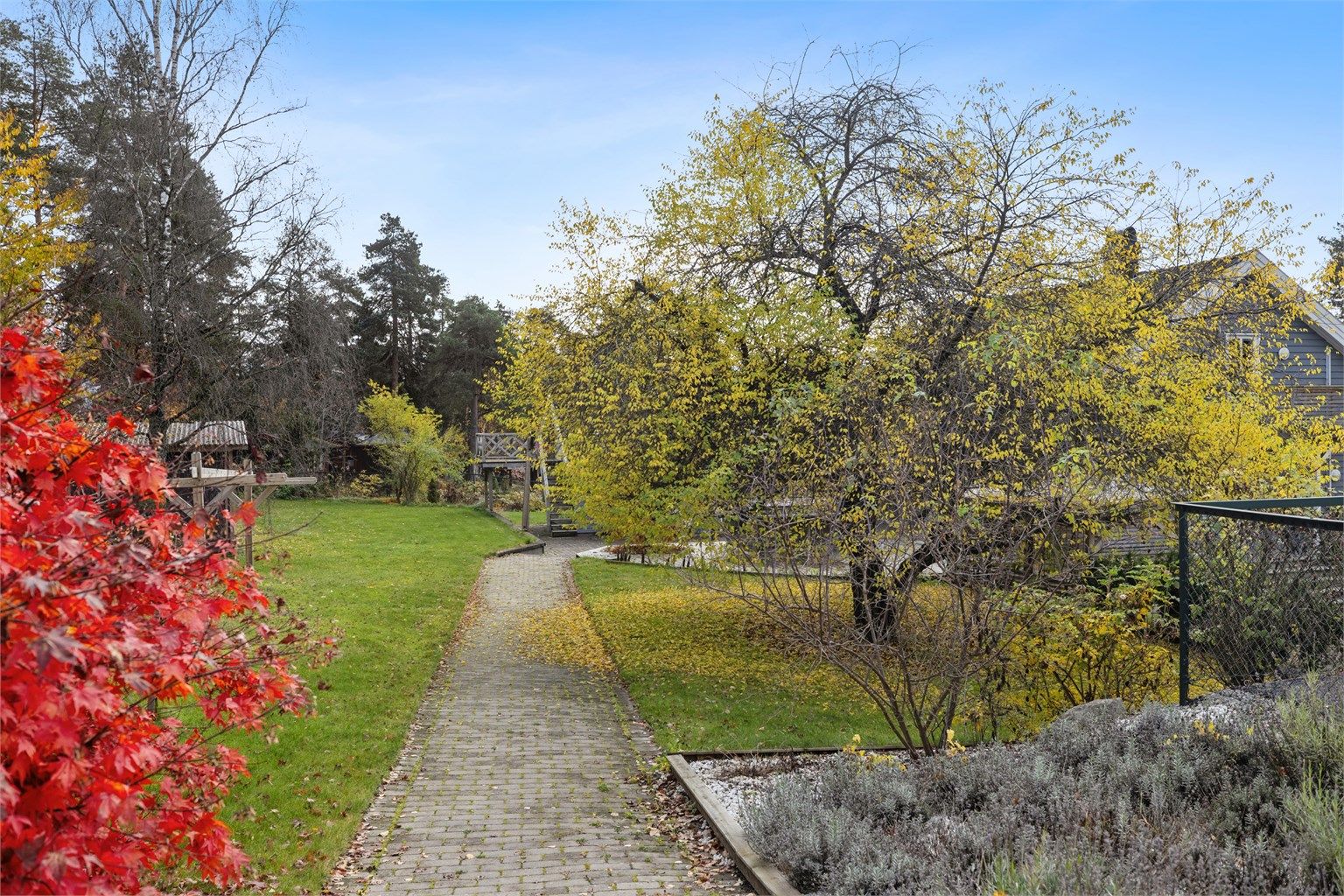 Adkomsten til eiendommen skjer via et sjarmerende, brosteinsbelagt inngangsparti, som gir en elegant og innbydende følelse allerede før du går inn døren