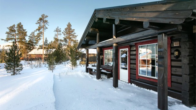 Stor støpt terrasse rundt deler av hytten med flere soner og sitteplasser