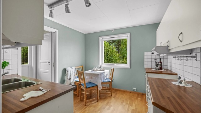 Kjøkkenet har slette fronter og laminatbenkeplate.