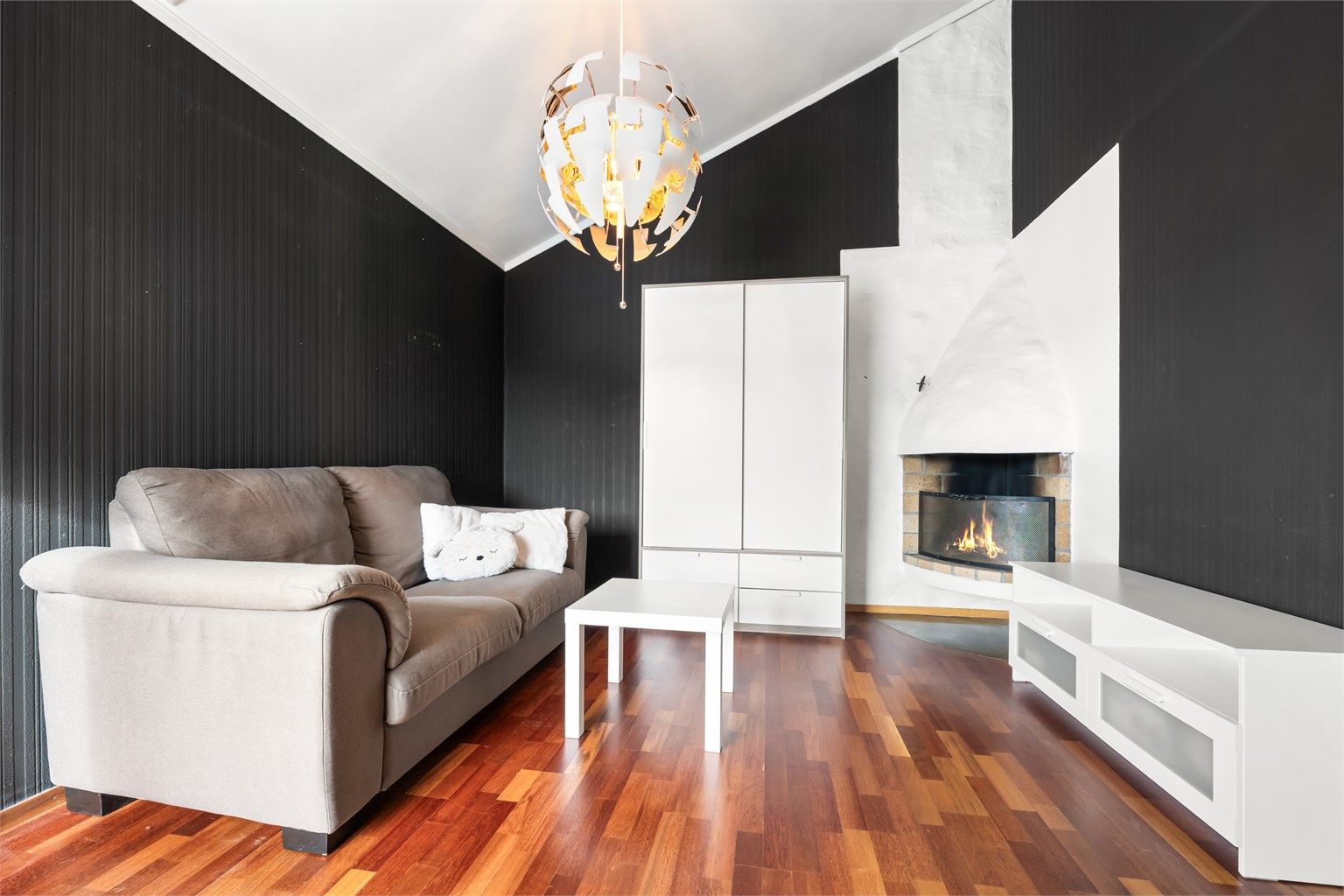 I tilknytning ligger en koselig peisestue, hvor ildstedet skaper en varm og innbydende stemning – perfekt for rolige kvelder og hyggelige sammenkomster.