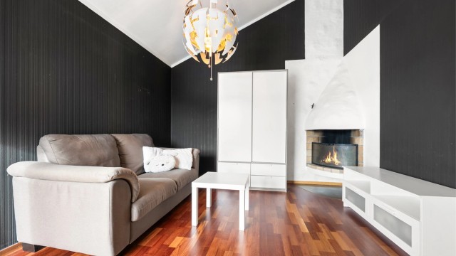 I tilknytning ligger en koselig peisestue, hvor ildstedet skaper en varm og innbydende stemning – perfekt for rolige kvelder og hyggelige sammenkomster.