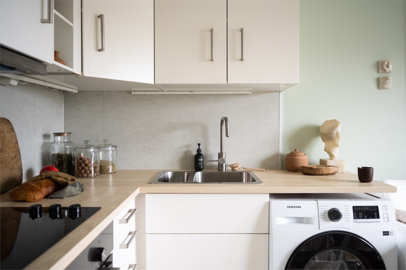 Kjøkkenet har en moderne innredning med glatte fronter, integrert platetopp og stekeovn. WaterGuard er installert ved kjøkkenbenken for ekstra trygghet.