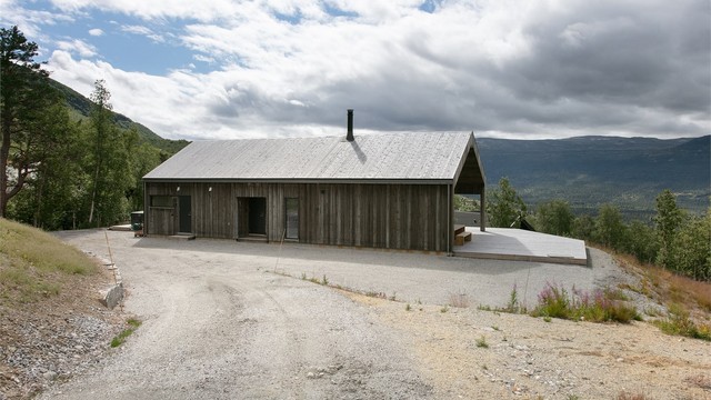 Hytta har en moderne arkitektur med stående bordkledning.