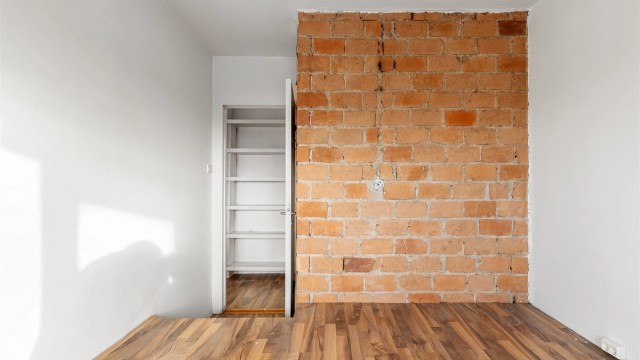 En eksponert teglsteinsvegg gir karakter til rommet, som også har en tilknyttet bod.