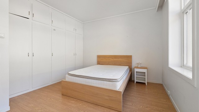En hel vegg med plassbygde garderobeskap gir rikelig med oppbevaringsplass på soverommet.