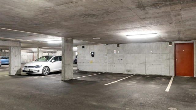 Fast parkering i lukket anlegg med elbillader.