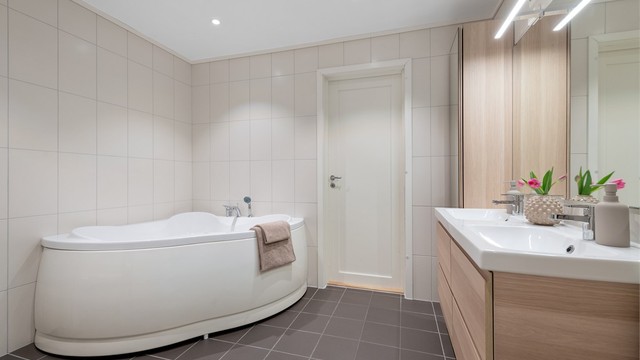 Hovedbadet i underetasjen er utstyrt med badekar og flislagt gulv med varmekabler.