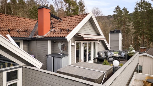 Gulvet på terrassen er belagt med sementbasert puss. Rekkverket er av tre.