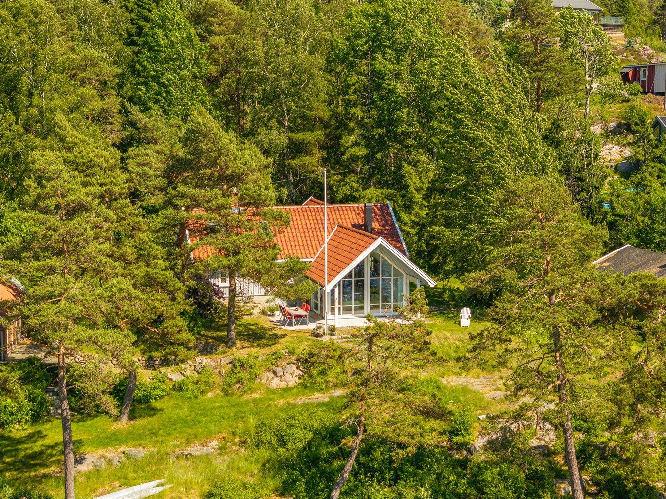 Naturlig vegetasjon med velvoksne trær gjør hytta lite fremtredende.