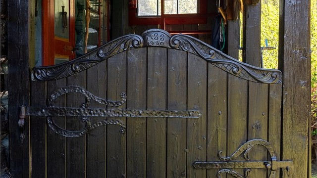 Håndverksdetaljer som smijernsbeslag og utskjæringer understreker den tradisjonelle stilen.