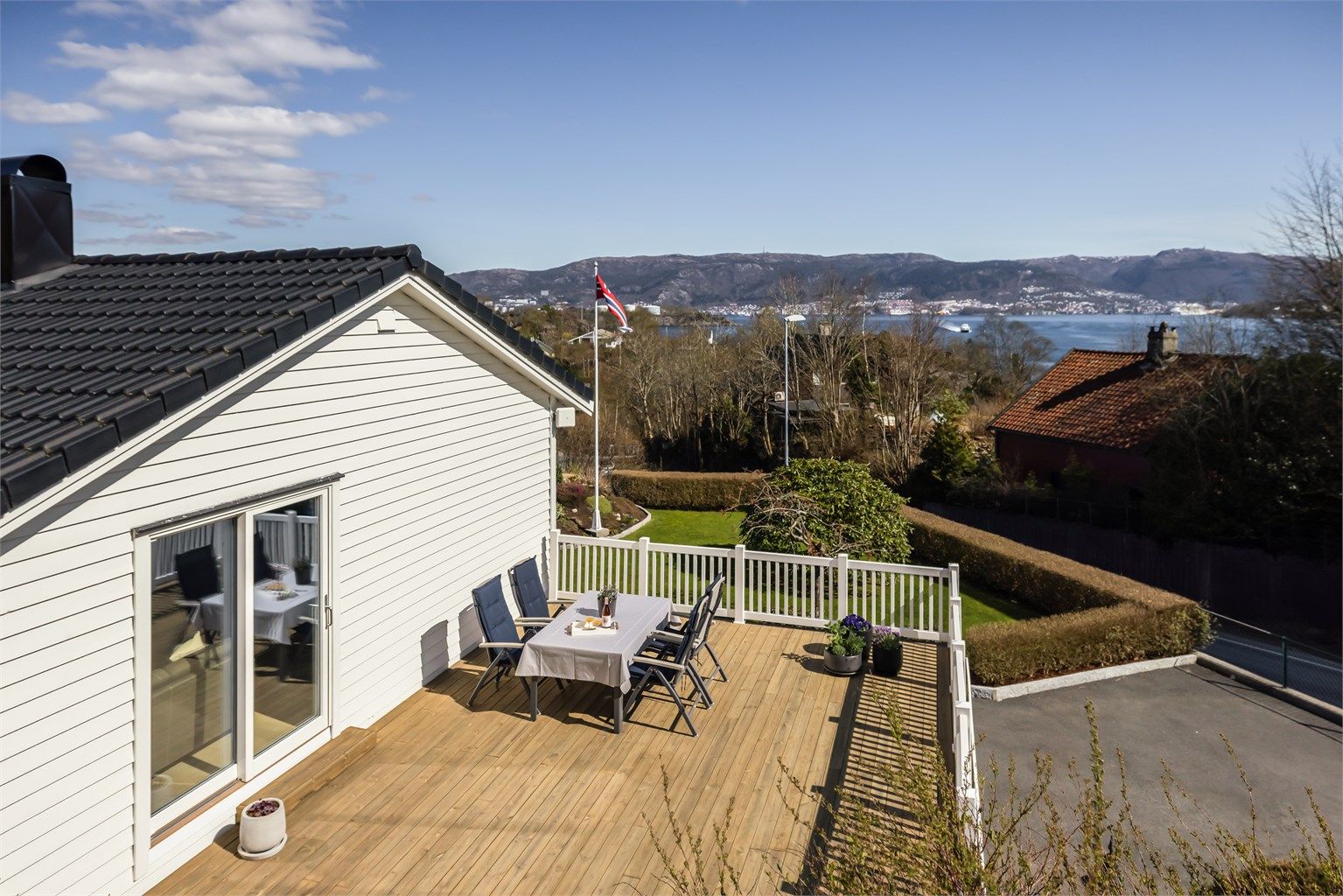 Uteplassen er pent rammet inn med hvitt rekkverk og har direkte tilgang fra stuen.