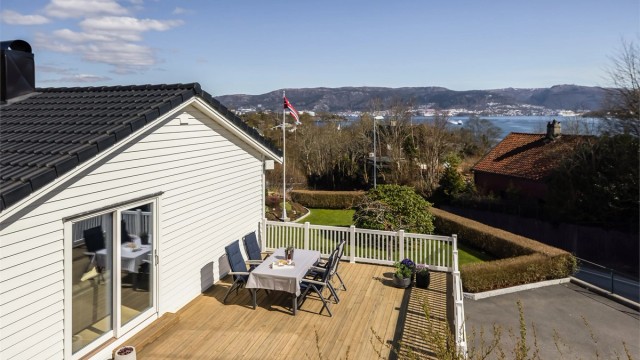 Uteplassen er pent rammet inn med hvitt rekkverk og har direkte tilgang fra stuen.