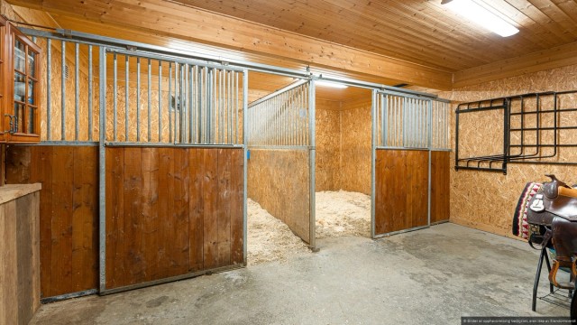 Hyggelig stall med to bokser. Varmepumpe i stallen sørger for godt klima for hestene. Plass til skap og oppbevaring av utsyr og mat. Foto: Beleven studio.
