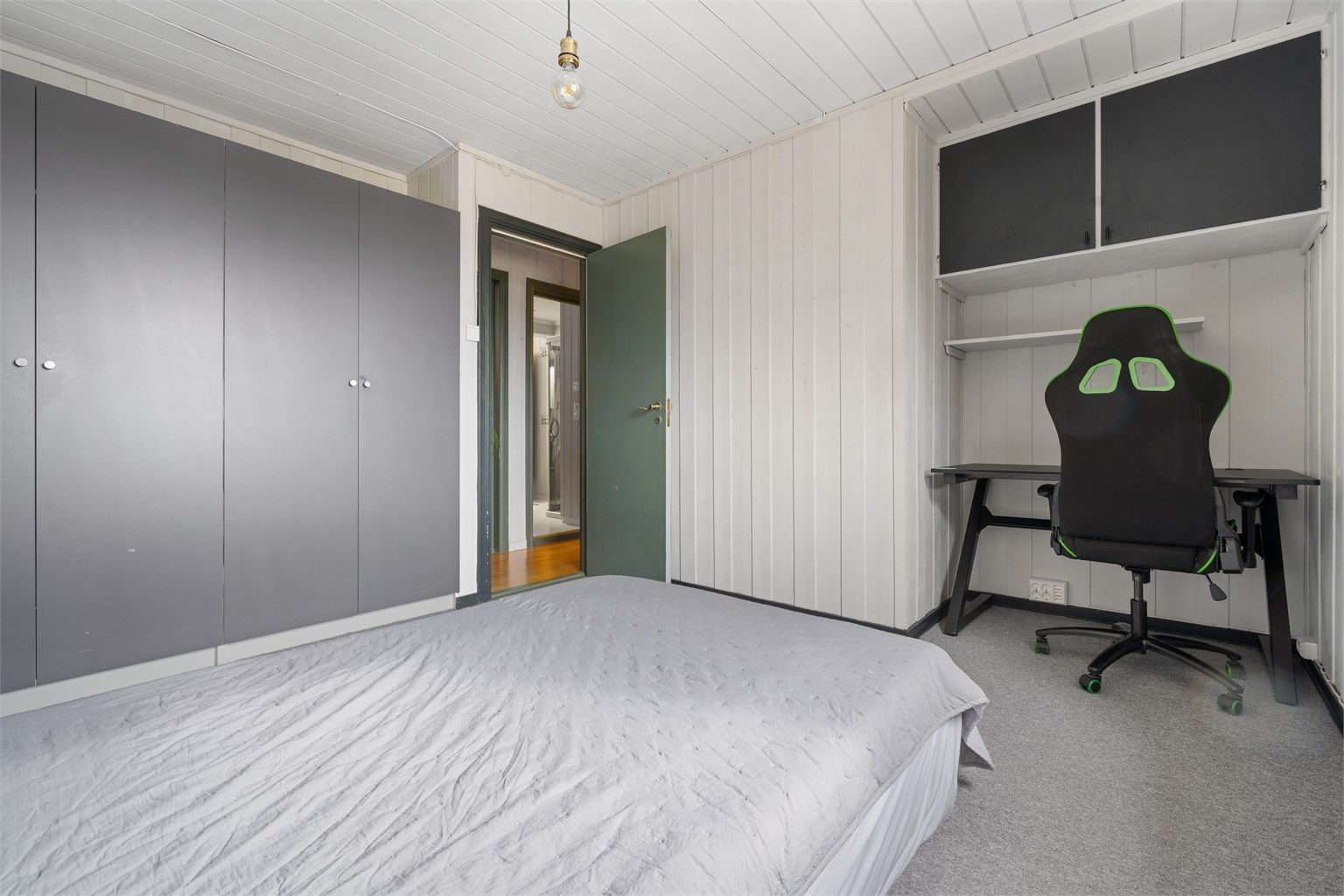 Et av boligens tre soverom, med plass til både seng, garderobe og en egen arbeidspult.