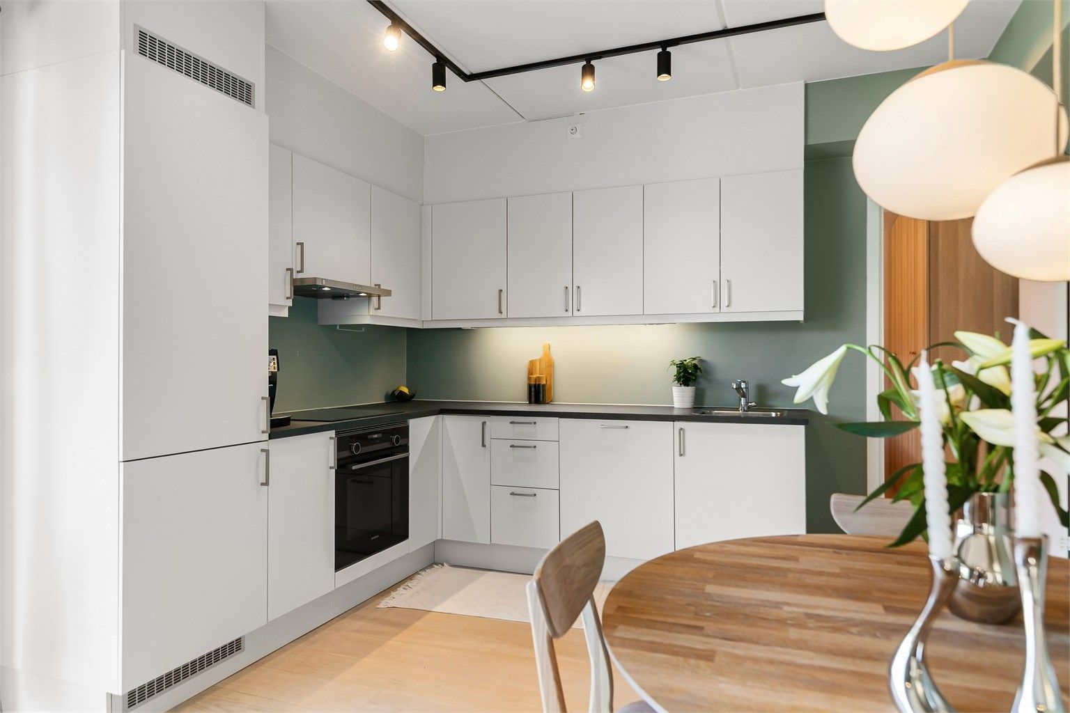 Kjøkkeninnredning fra byggeåret med glatte fronter og laminatbenkeplate.