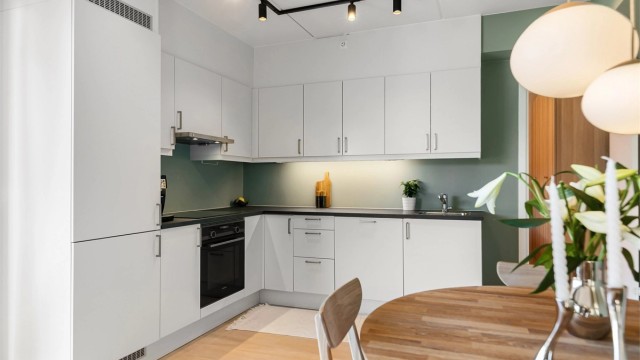 Kjøkkeninnredning fra byggeåret med glatte fronter og laminatbenkeplate.