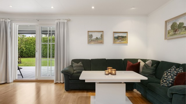 Store vindusflater og skyvedør slipper inn godt med dagslys og åpner ut mot hagen.