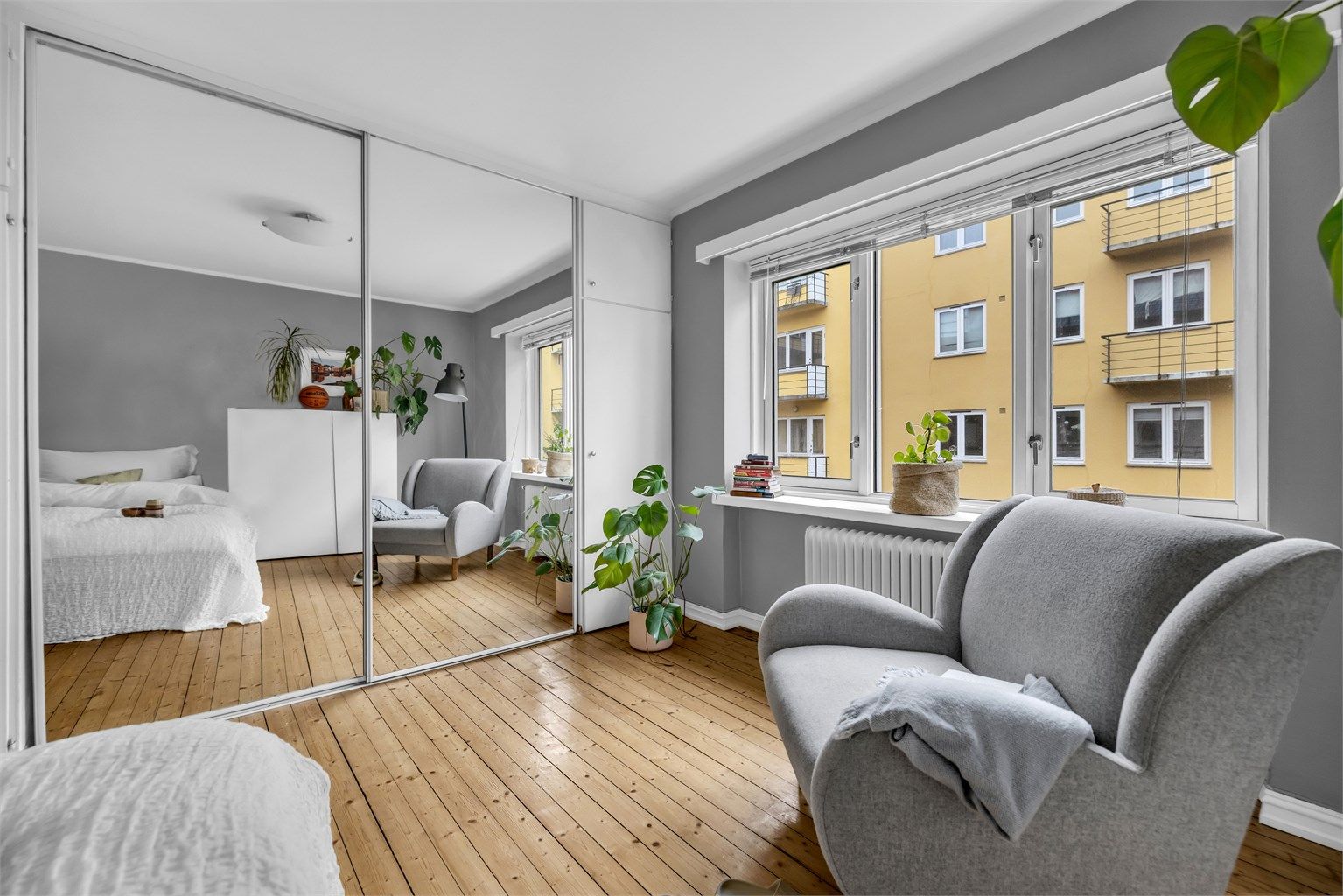 Store vindusflater i kombinasjon med takhøyden gir rommet en lys og luftig atmosfære.