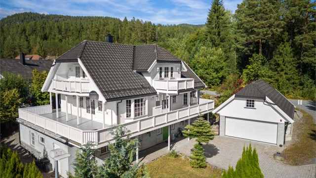 Balkongen strekker seg rundt to sider av boligen, i tillegg er det en flytende overgang med trapp ned til terrassen.