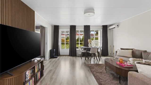Stuen har en stilfull spilevegg som gir rommet et moderne og gjennomført uttrykk.