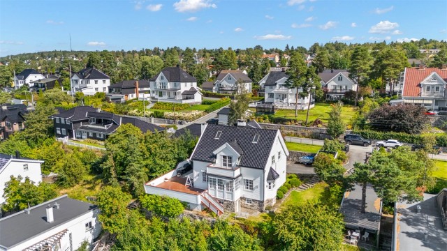 Stor og solrik tomt med utsikt som er pent opparbeidet med plenarealer, prydbusker og diverse beplantning. Asfaltert innkjøring og gårdsplass. Noe naturtomt i skråningen mot vest nedenfor terrassen