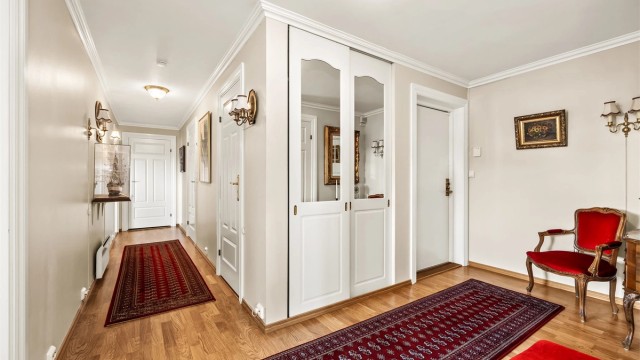 En innbydende entré og gang med parkett på gulv og god plass til garderobeløsning.