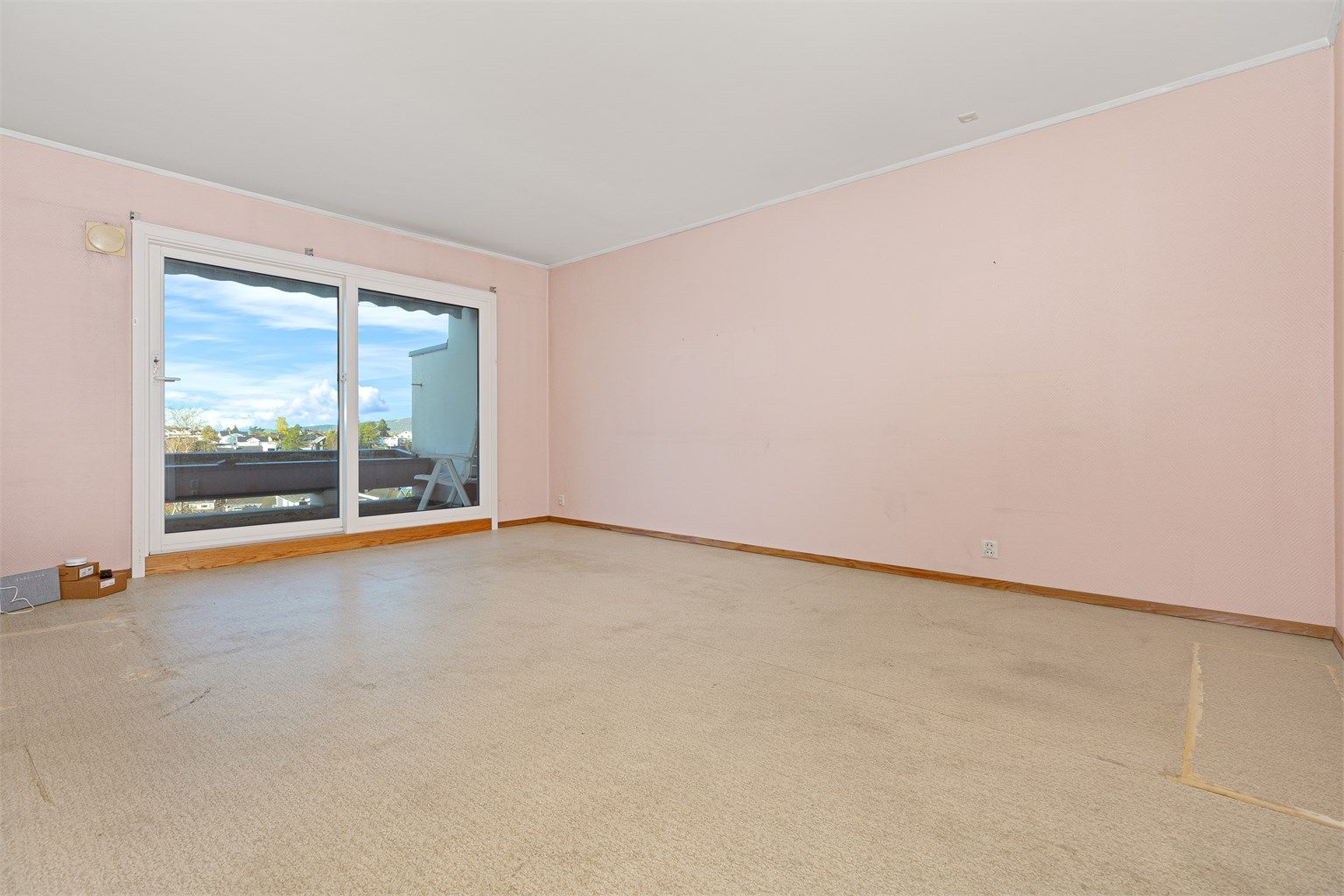 Romslig stue med store vinduer og utgang til vestvendt balkong. Her ligger alt til rette for å skape et lyst og trivelig oppholdsrom.