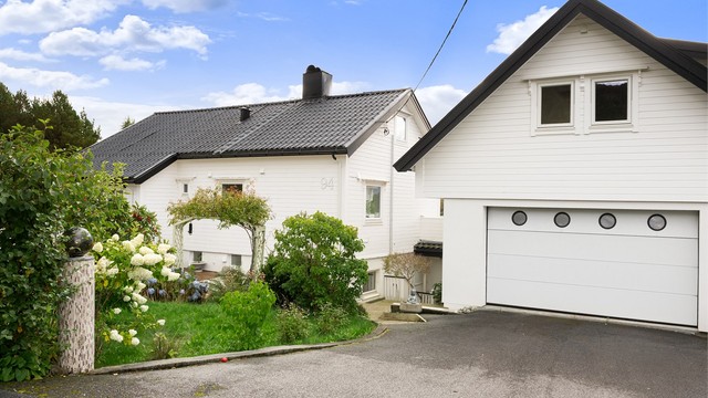 Fasade av garasje og bolighuset sett fra Myrlandsvegen