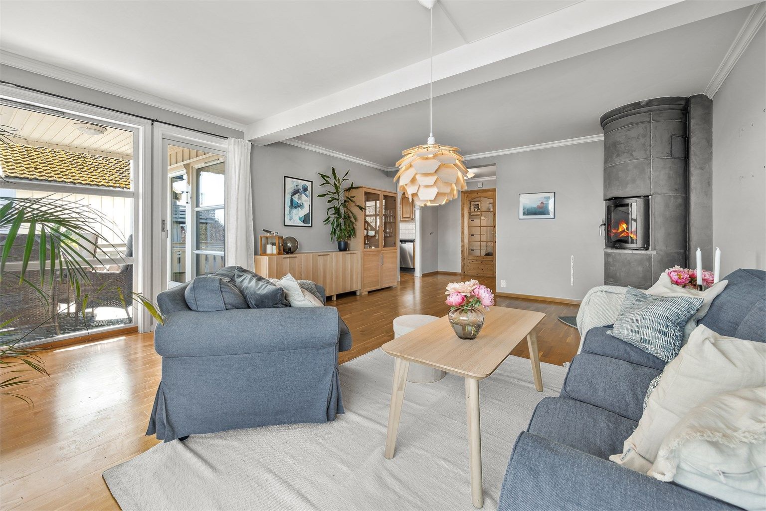 Stuen glir sømløst over i spiseplassen og kjøkkenet, og skaper et stort, sammenhengende oppholdsrom.