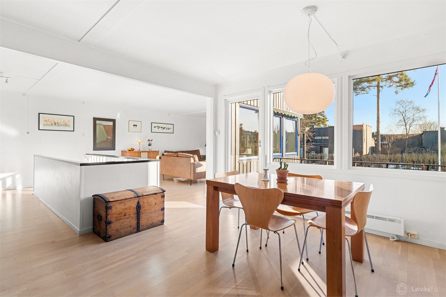 En lys og åpen spisedel med store vinduer.