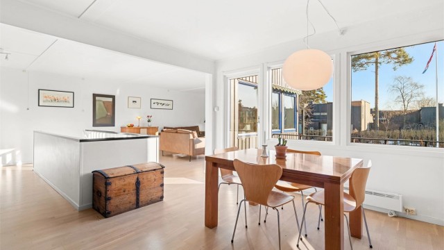 En lys og åpen spisedel med store vinduer.