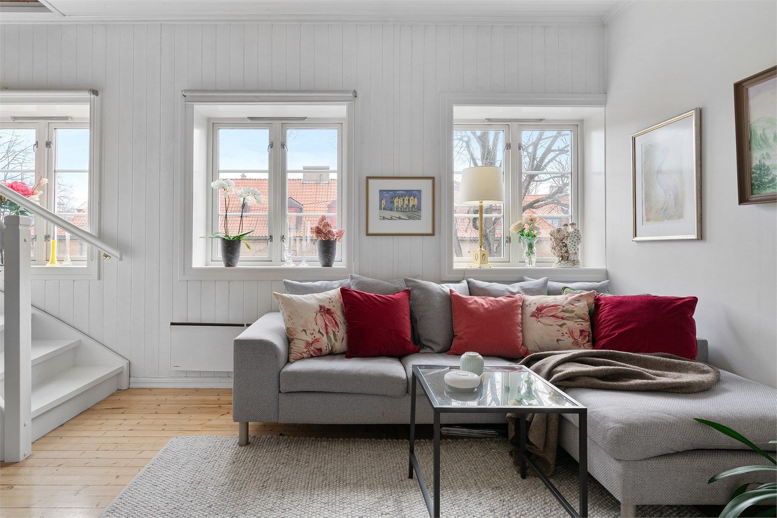 Fra de store vinduene har du trivelig utsyn mot hagebyen. 