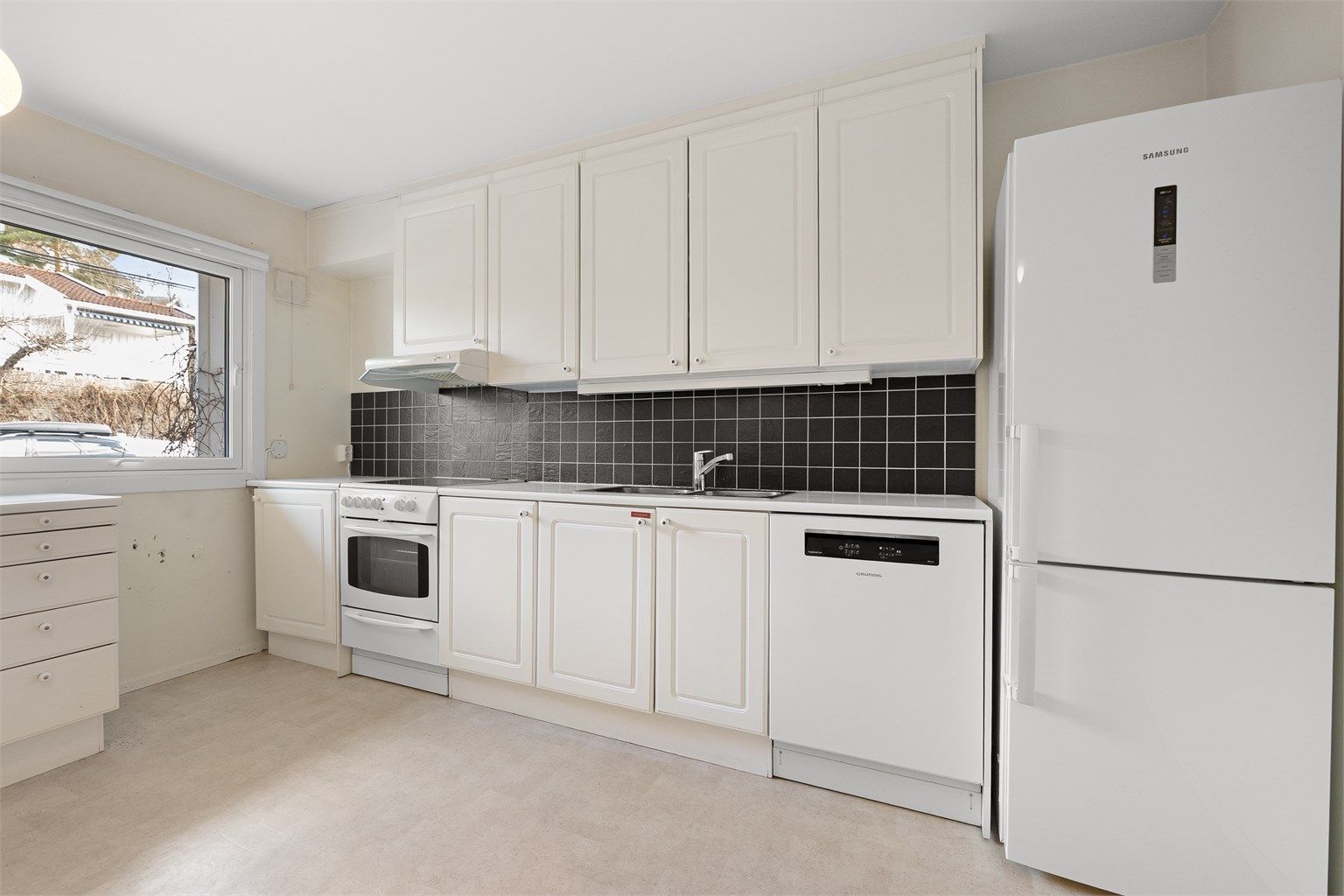 Praktisk kjøkken med profilerte fronter. Hvitevarer som komfyr, oppvaskmaskin og kjøleskap medfølger.