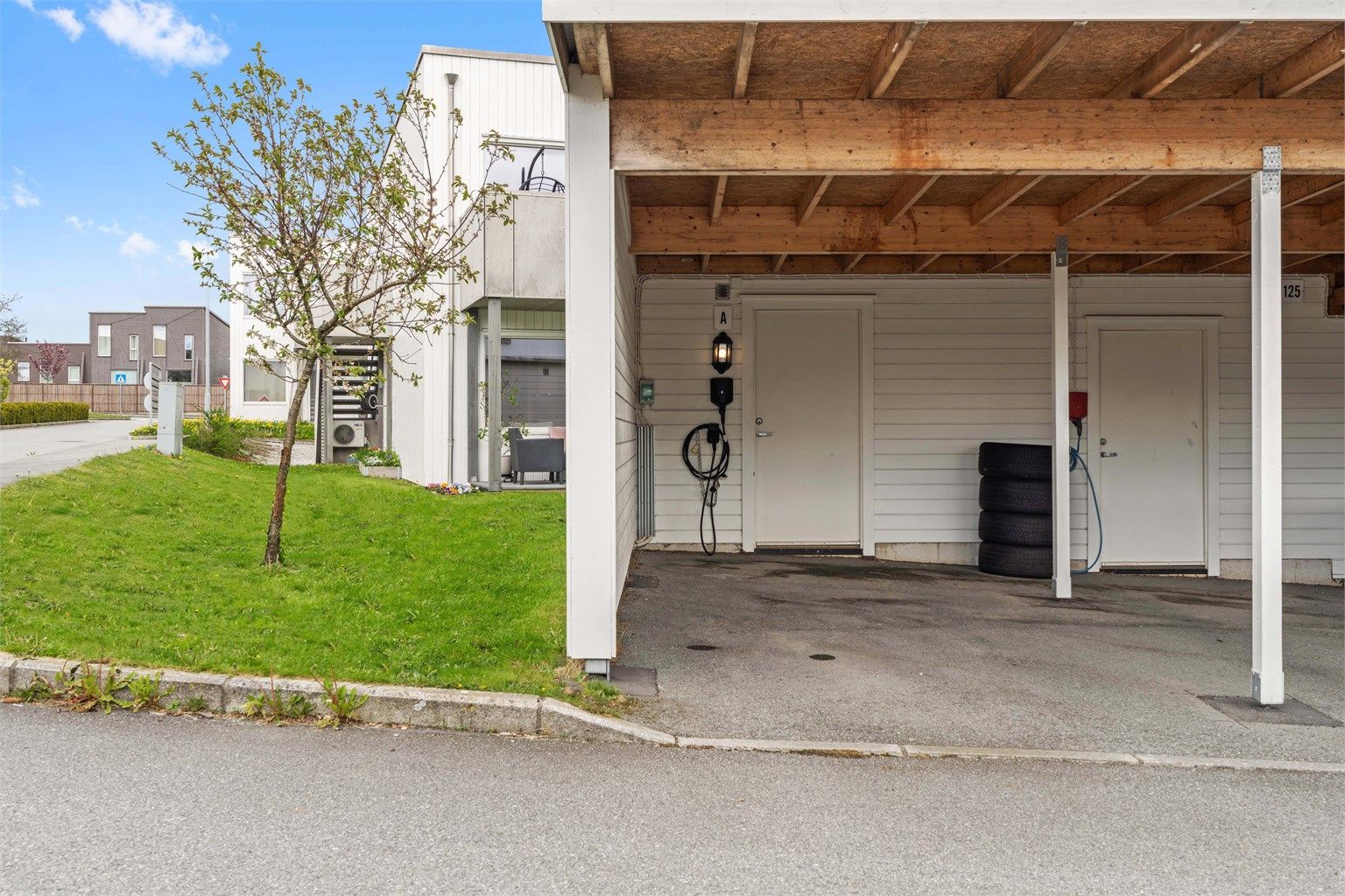 Parkeringsplassen er utstyrt med elbillader, og det er en ekstern bod i tilknytning til carporten.