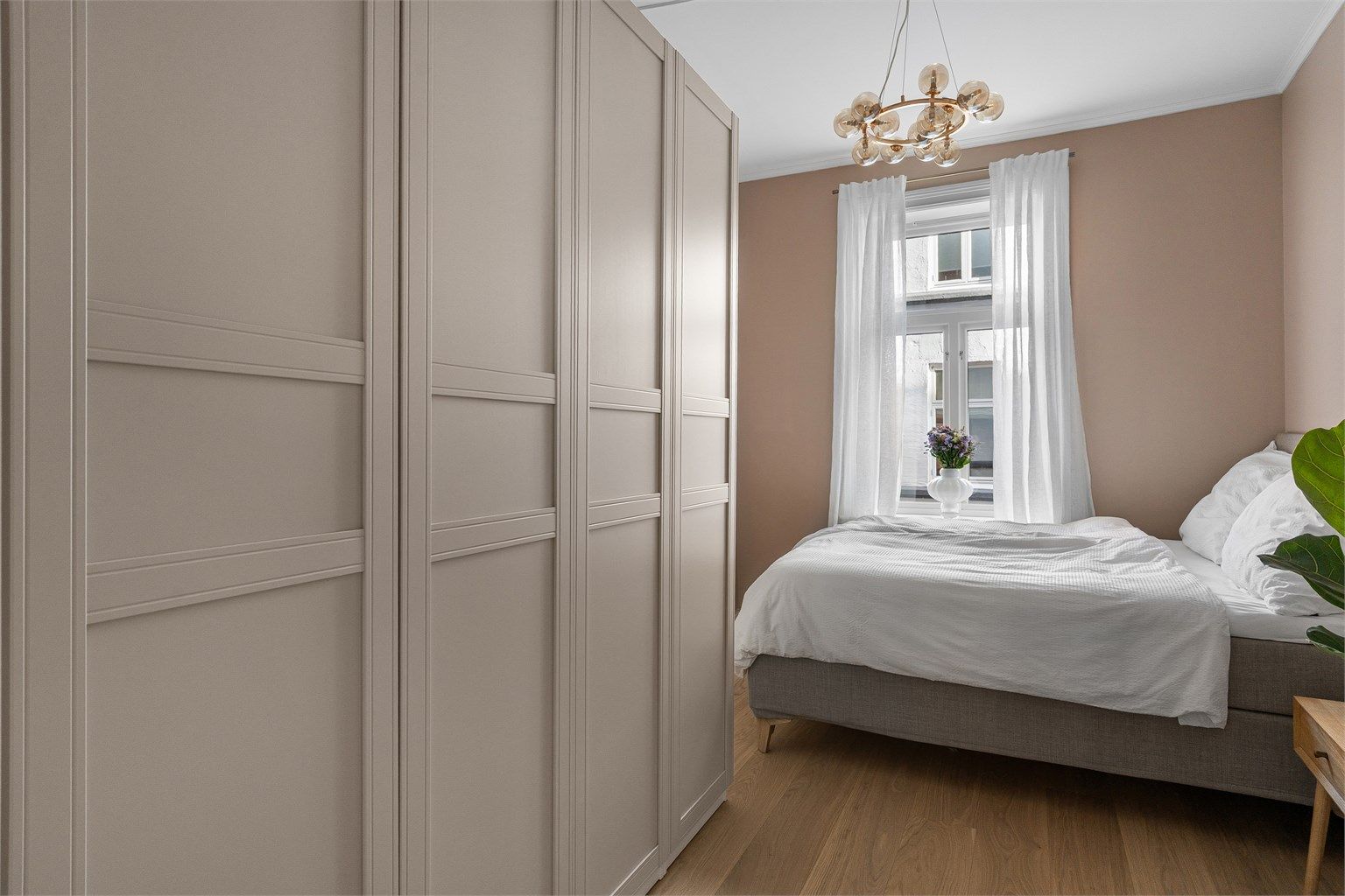 Boligens soverom er lyst og luftig, med god plass til seng og romslig garderobe. 