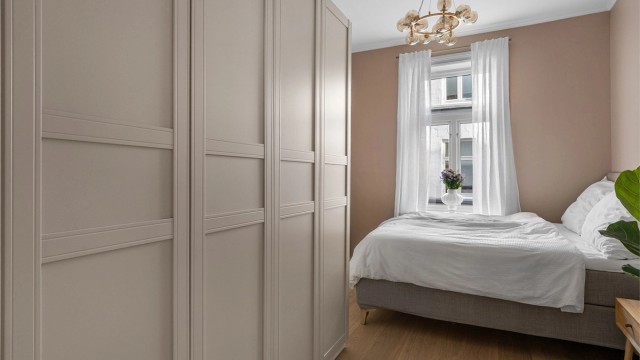 Boligens soverom er lyst og luftig, med god plass til seng og romslig garderobe.