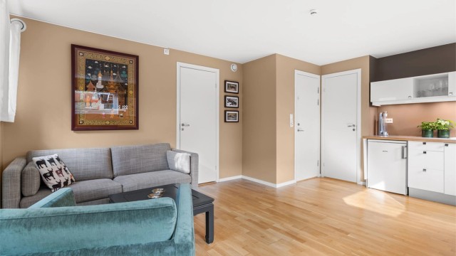 Stuen i hybelen er lett å møblere med plass til både sittegruppe og spisebord.