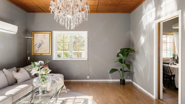 Stuen har god plass til hjørnesofa. Fra stuen er det direkte tilgang til kjøkkenet.