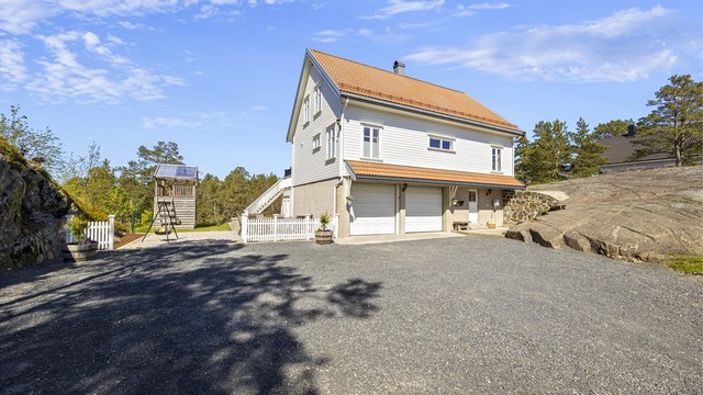 Eneboligen har en kombinasjon av liggende trekledning og murpuss på fasaden.