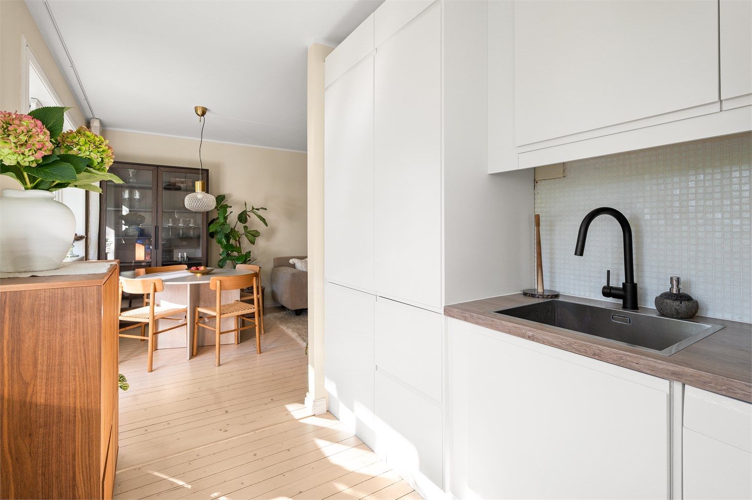 Moderne og delikat kjøkken med mye oppbevaringsplass i over- og underskap.