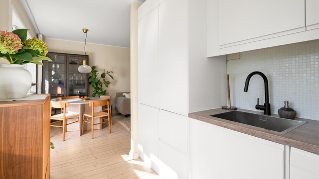 Moderne og delikat kjøkken med mye oppbevaringsplass i over- og underskap.