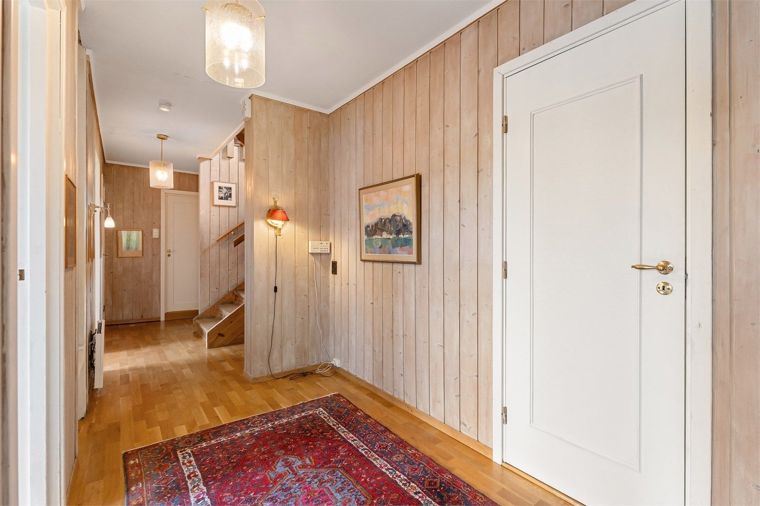 Gangen i underetasjen gir adkomst til alle rom og har en peiskamin for ekstra varme.