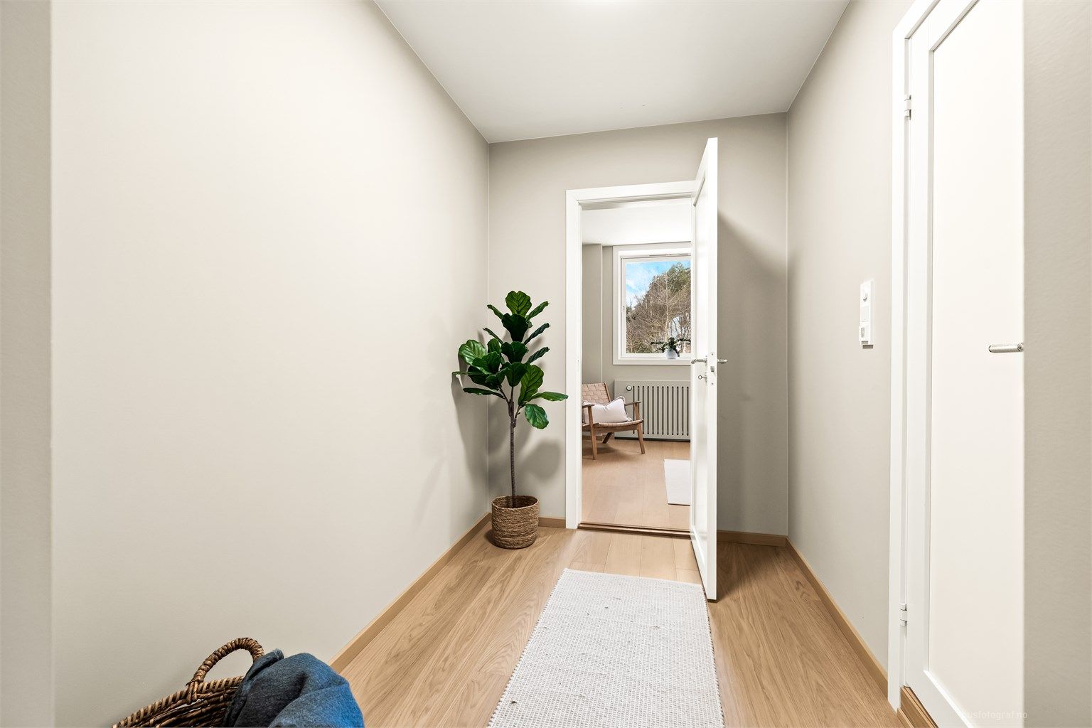 En lys og innbydende gang binder rommene i leiligheten sammen.