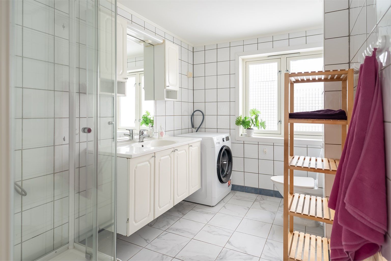 Romslig flislagt bad på i underkant av 6 kvm. God plass for vaskemaskin