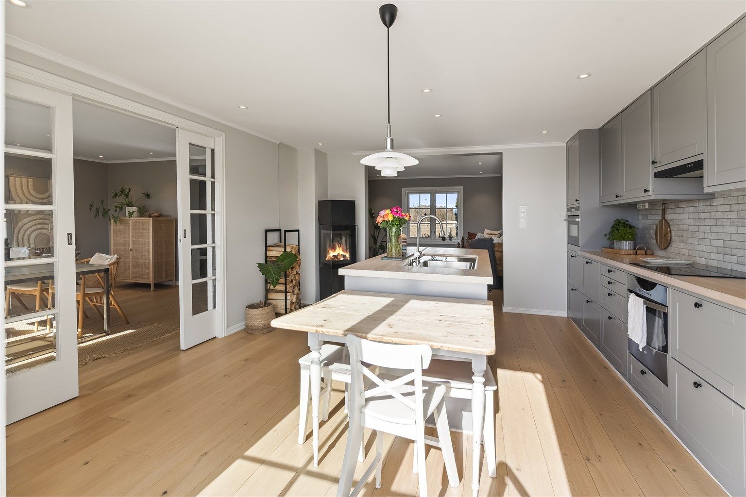 Fra kjøkkenet er det delvis åpen løsning mot stuen. Peisovnen fra Jydepeisen skaper en lun atmosfære.