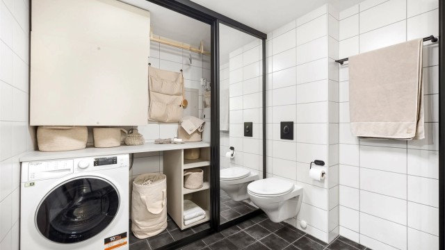 Bak skyvedørene på badet skjuler det seg en smart og arealeffektiv vaskeromsløsning.