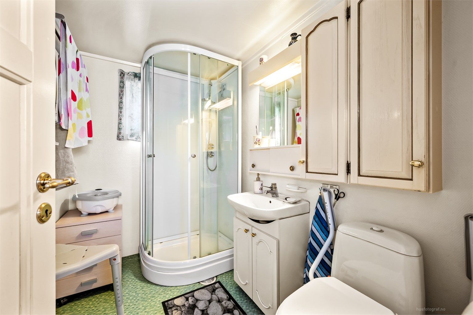 Badet i første etasje er fra 1989 og er utstyrt med dusjkabinett, toalett og servant med skap.