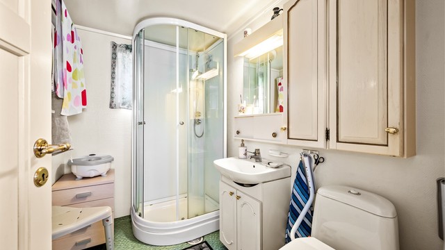 Badet i første etasje er fra 1989 og er utstyrt med dusjkabinett, toalett og servant med skap.