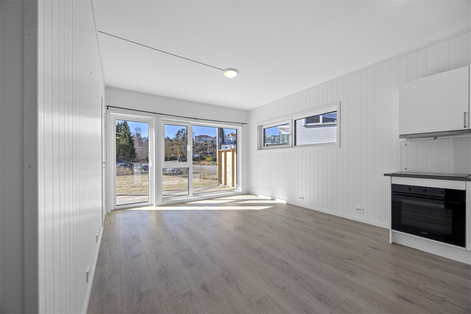 Åpen stue- og kjøkkenløsning med direkte utgang til terrassen.