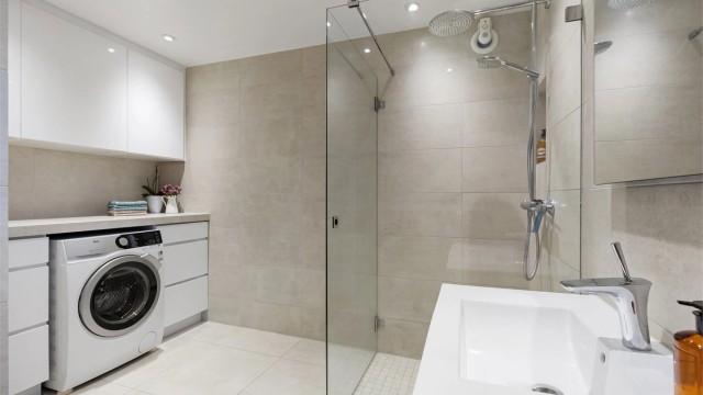 Badet er praktisk innredet med opplegg for vaskemaskin, overskap og regndusj.
